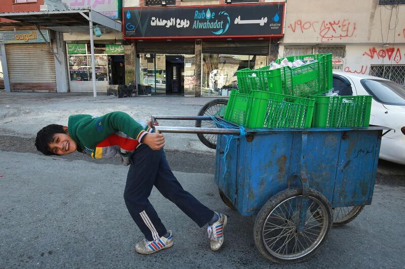 A child pulls a handcart in the Wahdat district of Jordan's capital Amman. Many children have been forced into working due to the economic impact of the Covid-19 pandemic. AFP