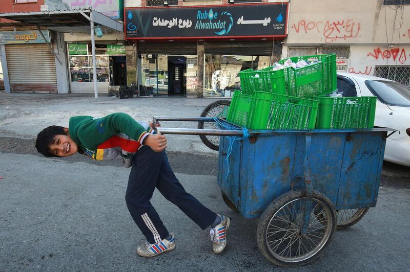 A Jordanian youth uses a hand cart to work in Amman's Wahdat district. Many minors have been forced prematurely into the labour market in Jordan due to the Covid-19 pandemic, experts say. Schools in Amman and throughout the country have been closed for nearly a year now, while economic fallout from the pandemic has eaten into breadwinners' ability to feed their families. AFP