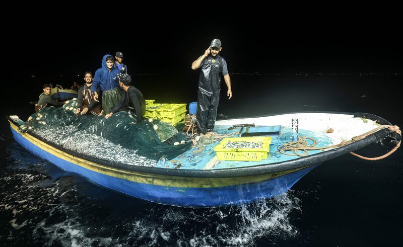 Palestinian fisherman Mohammed Al Nahal, right, and members of his team return to the coast of Gaza city to unload their catch.