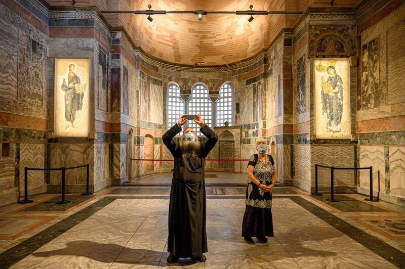 A priest and a woman visit the Chora or Kariye Museum. AFP