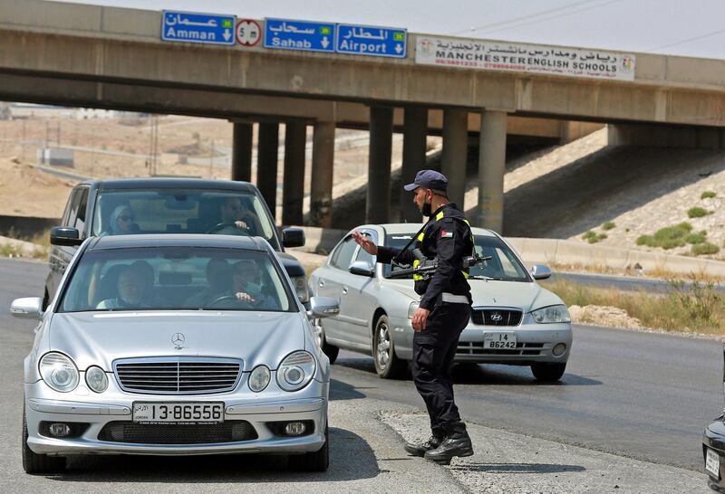 A member of Jordanian security forces stops cars as the police and army close-off the area surrounding the site of an explosion at a military munitions depot in the city of Zarqa, 25 Km (15 miles) east of the capital Amman, on September 11, 2020. - A huge blast rocked a Jordanian military munitions depot early sparking a large fire, but the army said there were no casualties at the base situated in an uninhabited area, adding in a statement that the explosion was "due to high temperatures provoking a chemical reaction in a shell". (Photo by Khalil MAZRAAWI / AFP)