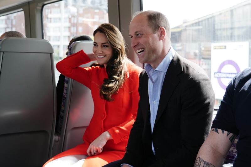 The prince and princess smile on the Elizabeth Line. PA