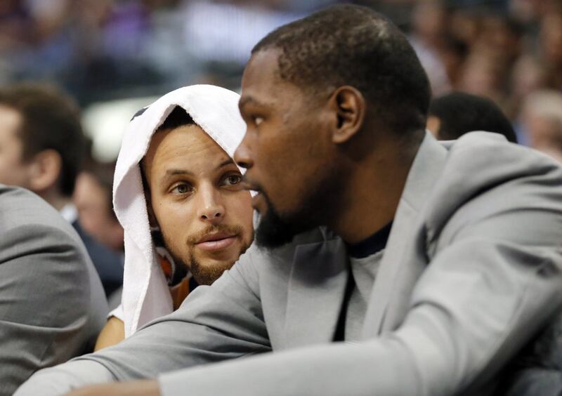 Golden State Warriors guard Stephen Curry, left, talks with Kevin Durant, right, on the bench during their game against the Dallas Mavericks on Tuesday, March 21, 2017, in Dallas. Tony Gutierrez / AP
