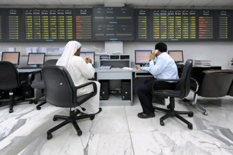 Traders work at the Bahrain stock exchange in Manama, which is considering merging with another bourse. Phil Weymouth / Bloomberg News