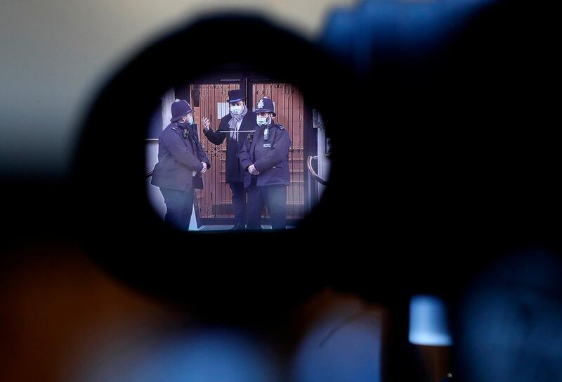 Police officers are seen through a camera view finder as they stand outside King Edward VII hospital. AP Photo