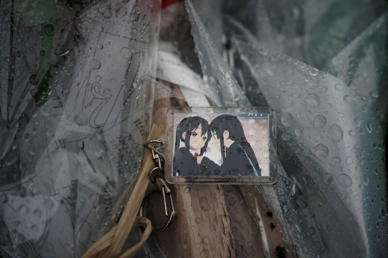 A keychain with a cartoon image is placed on top of flowers. AP Photo