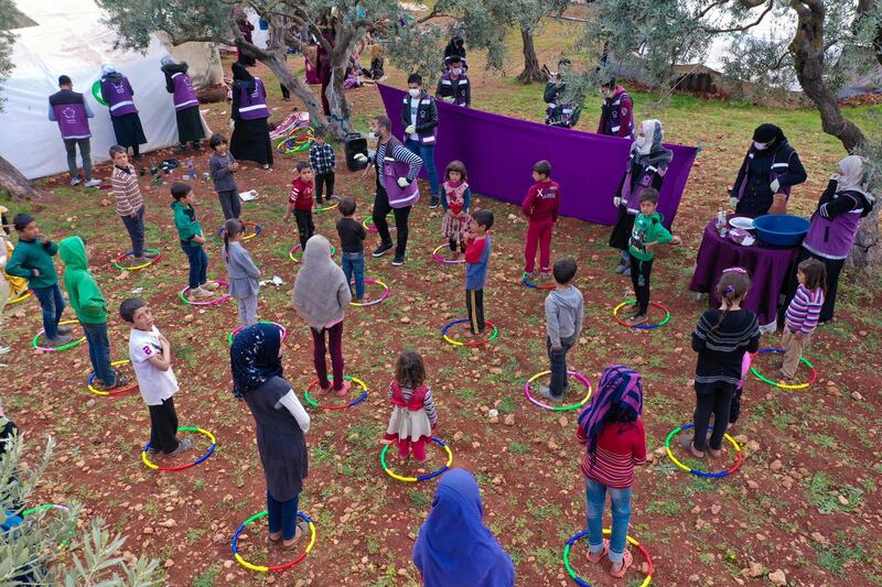 Volunteers perform a puppet show for children in a camp for displaced Syriansn the village of Kafr Yahmul, north of the Syrian city of Idlib.  AFP