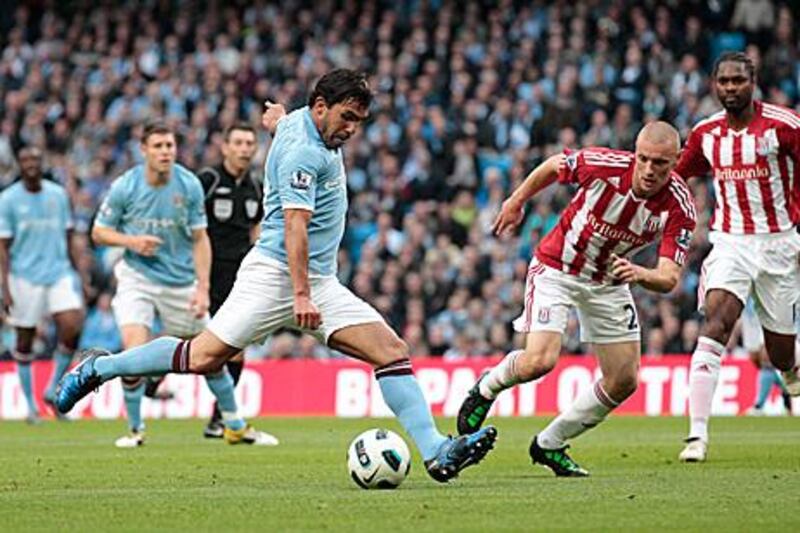 Carlos Tevez scores the opening goal in Man City's 3-0 win against Stoke City.