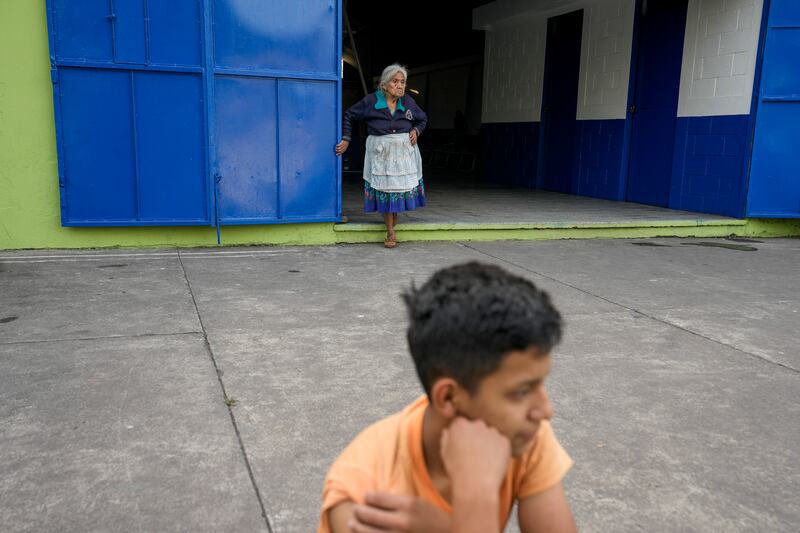 People wait outside a gym set up as a shelter for those evacuating from the slopes of the Fuego volcano, which is showing increased activity, in Santa Lucia Cotzumalguapa, Guatemala.  AP Photo 