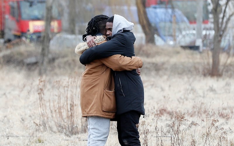 Two students from Eswatini comfort each other after they managed to cross from Ukraine into Romania, on February 27, 2022. EPA