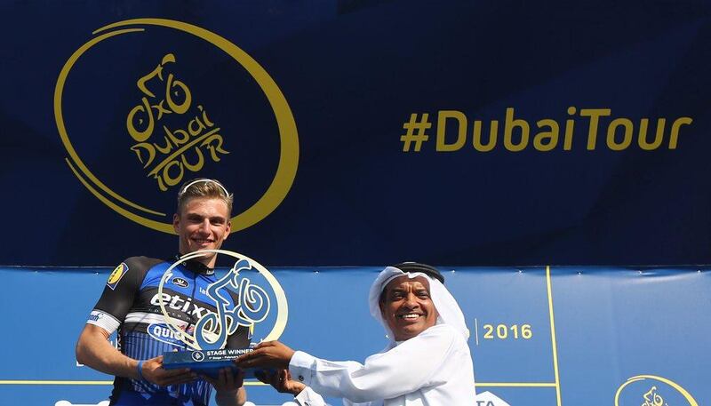 German cyclist Marcel Kittel of Etixx-Quick-Step team (L)receives his trophy from UAE official Jumaa al-Mtarushi after winning the first stage of Dubai Tour 2016 in the United Emirate of Fujairah on February 3, 2016.       / AFP / MARWAN NAAMANI