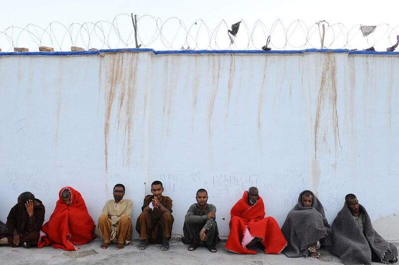 Afghan patients rest behind a barbed wire wall.