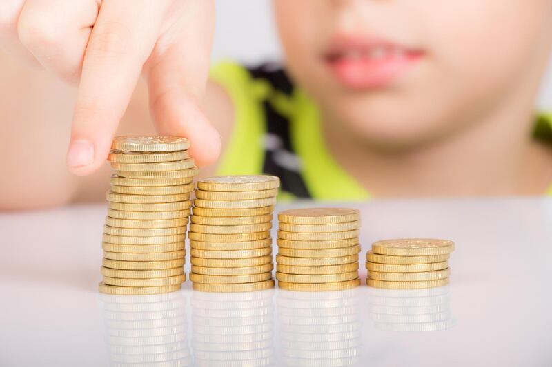 F0Y41K young boy counting his golden coins