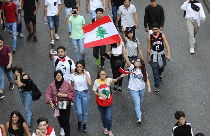 Lebanese students wave the national flag during a demonstration in the capital Beirut on November 9, 2019, as protesters keep up their three-week-long movement against a political class regarded as incompetent and corrupt. / AFP / ANWAR AMRO
