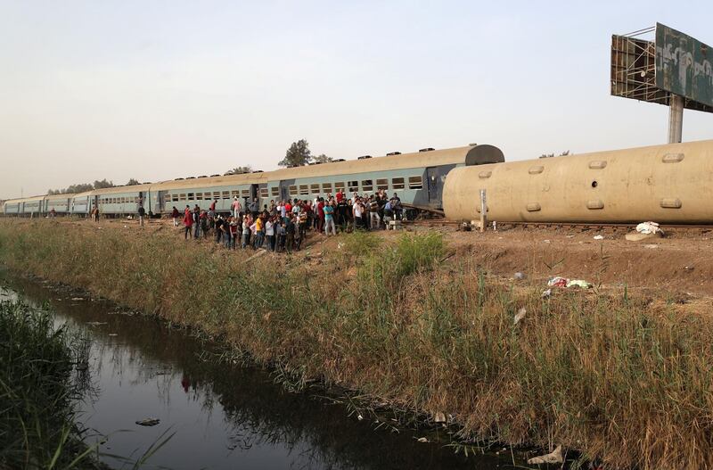 People gather at the site where train carriages derailed in Qalioubia province, north of Cairo, Egypt. Reuters