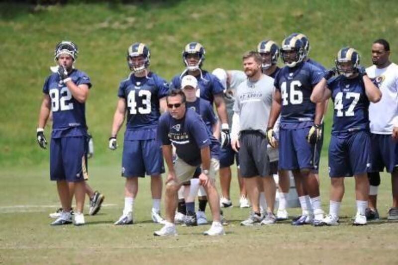 Jeff Fisher, centre, St Louis Rams head coach, does not think he needs to watch his veterans day and night during camp. He will let players with four-plus years in the NFL commute to pre-season training.