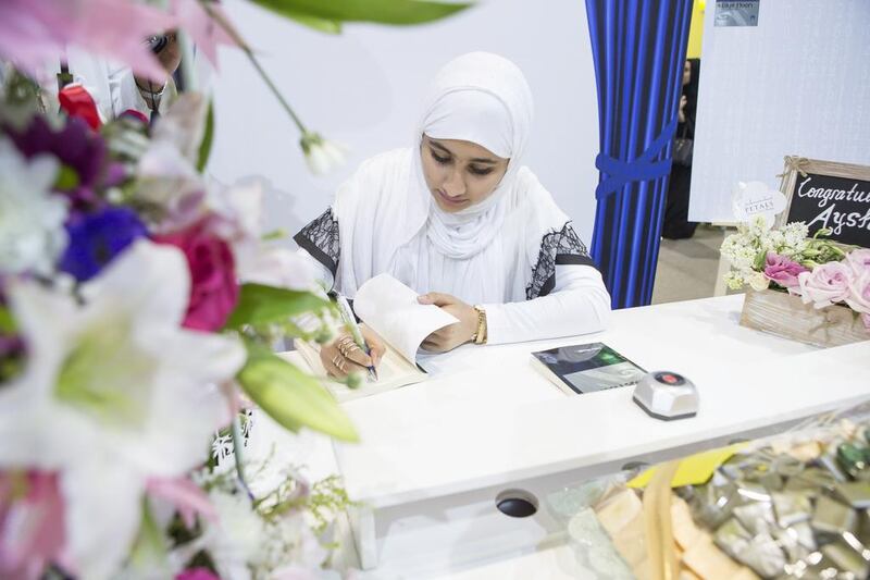 Aysha Al Naqbi signs copies of her novel Blue Moon at the Abu Dhabi International Book Fair Antonie Robertson / The National