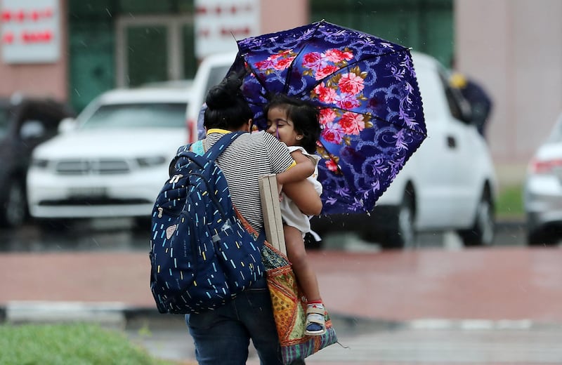 DUBAI, UNITED ARAB EMIRATES , Nov 10  – 2019 :- Mother with her child during the rain in discovery gardens area in Dubai. ( Pawan Singh / The National )  For News