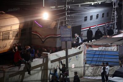People gather at the site of a passenger train that was derailed in Al Qalyubia governorate. EPA