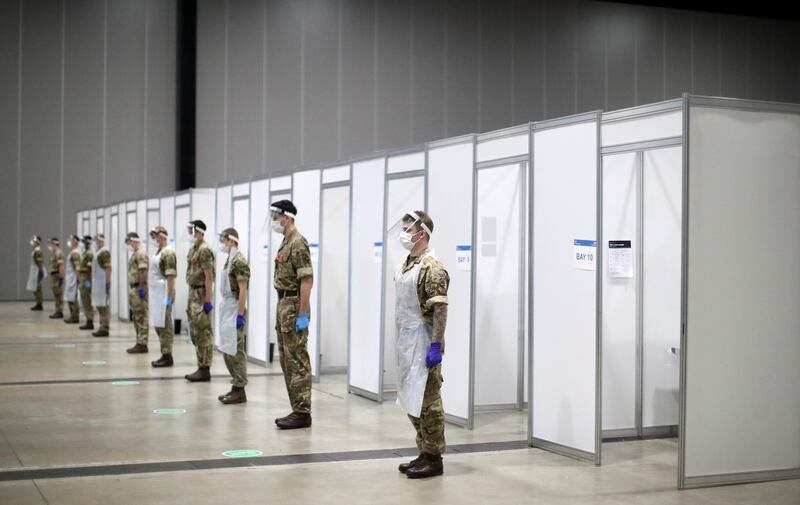 Soldiers stand as they observe a two-minute silence at a coronavirus disease testing centre in Liverpool. Reuters