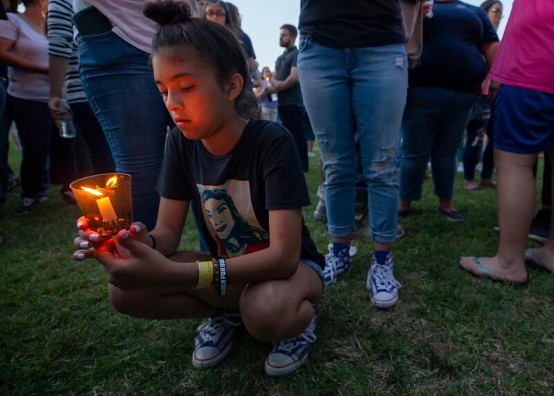 London Delgado kneels with a lighted candle at a vigil held in the wake of a deadly school shooting with multiple fatalities at Santa Fe High School, in Galveston, Texas. Stuart Villanueva / AP Photo