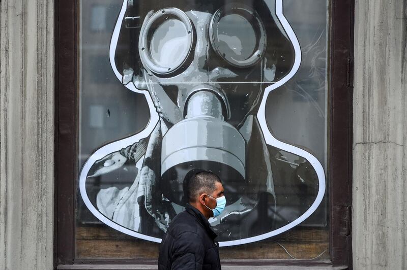 A man wearing a protective face mask walks past a military store in St Petersburg during a  lockdown in Russia aimed at stopping the spread of the coronavirus. AFP