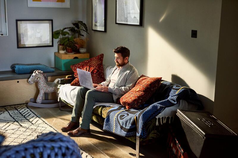 Portrait of man on sofa using laptop in living room, small business, online, industrious, efficiency