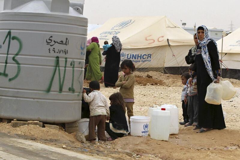 Syrian refugee women collect water at the Zaatari refugee camp in the Jordanian city of Mafraq, near the border with Syria. Muhammad Hamed / Reuters / March 8, 2014