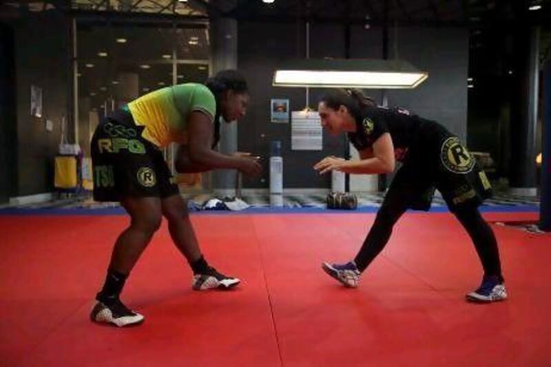 Caroline de Lazzer (black shirt) and Rosangela Conceicao (green shirt), train together in a room inside of the officers club. The two met while wrestling on the national team in Brazil.