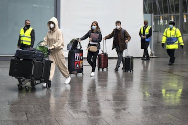 Passengers arriving at Heathrow Airport are escorted by security staff to buses heading to London. Getty Images