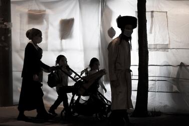 An ultra-Orthodox family passing next to sukkah (hut) during the Sukkot holiday, the Feast of the Tabernacles, in the ultra-Orthodox neighbourhood of Meah Shearim, Jerusalem, Israel, October 7. Atef Safadi / EPA
