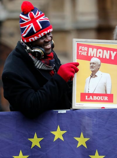 A protester holds a poster depicting Labour party leader Jeremy Corbyn in London, Wednesday, Jan. 16, 2019. British lawmakers overwhelmingly rejected Prime Minister Theresa May's divorce deal with the European Union on Tuesday, plunging the Brexit process into chaos and triggering a no-confidence vote that could topple her government. (AP Photo/Frank Augstein)