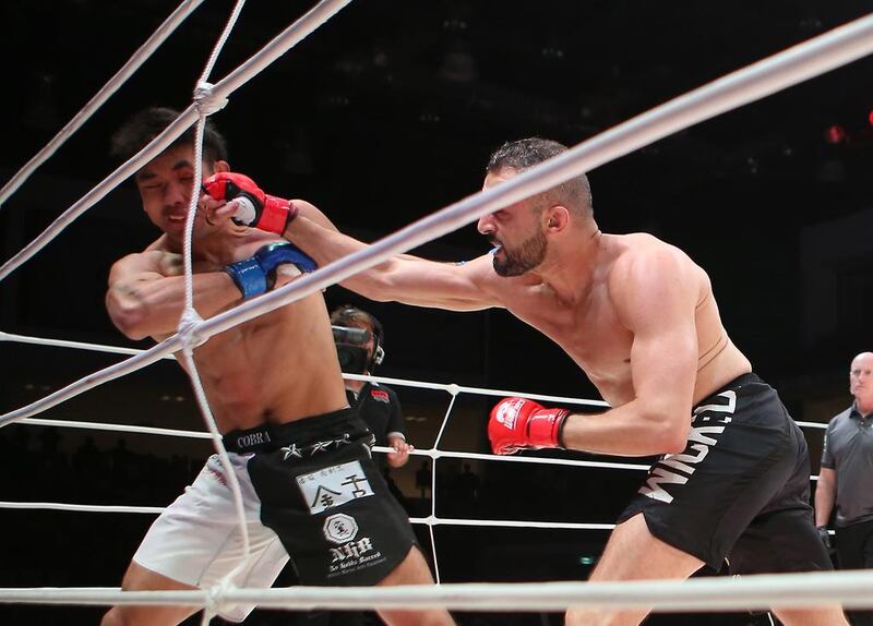 Tahar Hadbi from Algeria, in black shorts, fights Yoichiro Satofrom from Japan in the Abu Dhabi Warriors 4 at IPIC Arena in Zayed Sports city in Abu Dhabi. Ravindranath K / The National
