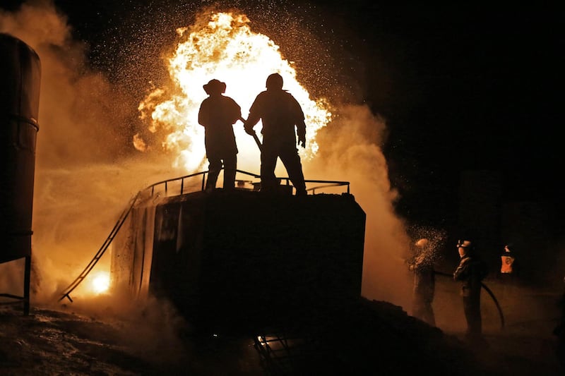 Members of the Syrian Civil Defence fight a fire which erupted after a bombardment of makeshift oil refining installations in the Tarhin area, near the Turkish-controlled city of Al Bab in the north of Aleppo province. AFP