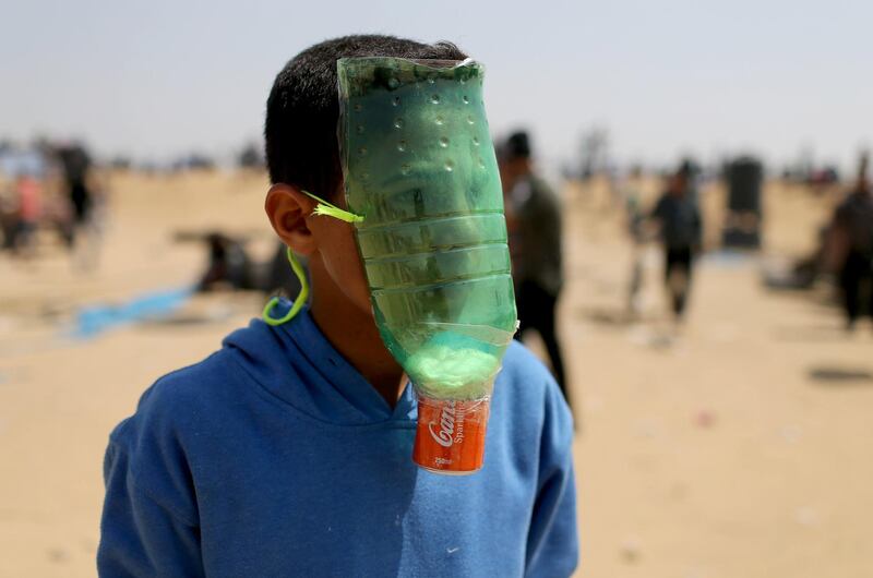 A Palestinian youth protects himself from inhaling Israeli tear gas with a homemade mask. Ibraheem Abu Mustafa / Reuters