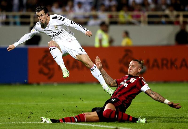 Gareth Bale of Real Madrid strikes at goal as he is tackled by Philippe Mexes of AC Milan during the Dubai Football Challenge match between AC Milan and Real Madrid at The Sevens Stadium on December 30, 2014 in Dubai, United Arab Emirates.  (Photo by Warren Little/Getty Images)