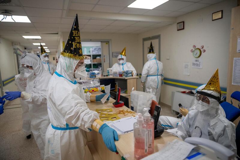 Healthcare workers in personal protective equipment celebrate the new year in Rome, Italy. Getty Images