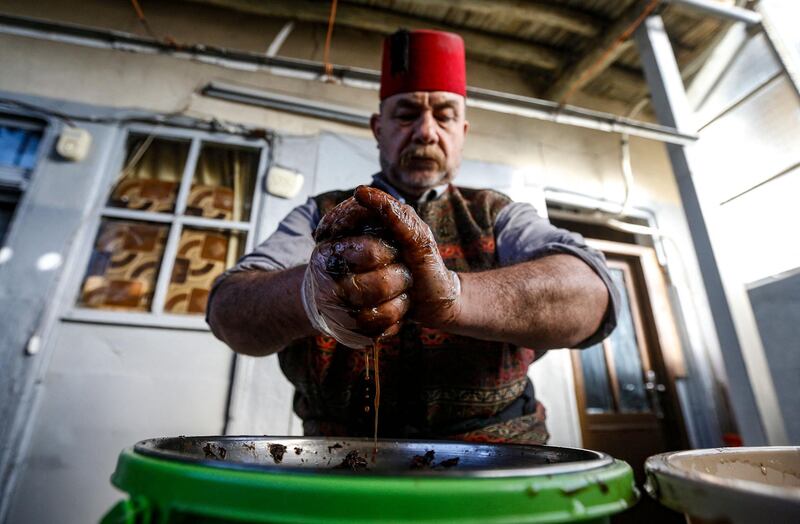 Ishaaq Kremed, a tamarind-juice seller, extracts juice from the fruit at his home in the Syrian capital Damascus. The popular street vendor says he usually has more customers during Ramadan, during which many Muslims favour the drink to break their day-long fast at sundown. AFP