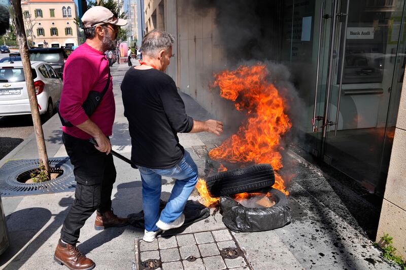 Protesters burn tyres outside the Bank Audi branch. Amid Lebanon's economic meltdown, bank customers have had restrictions on withdrawals since 2019. AP