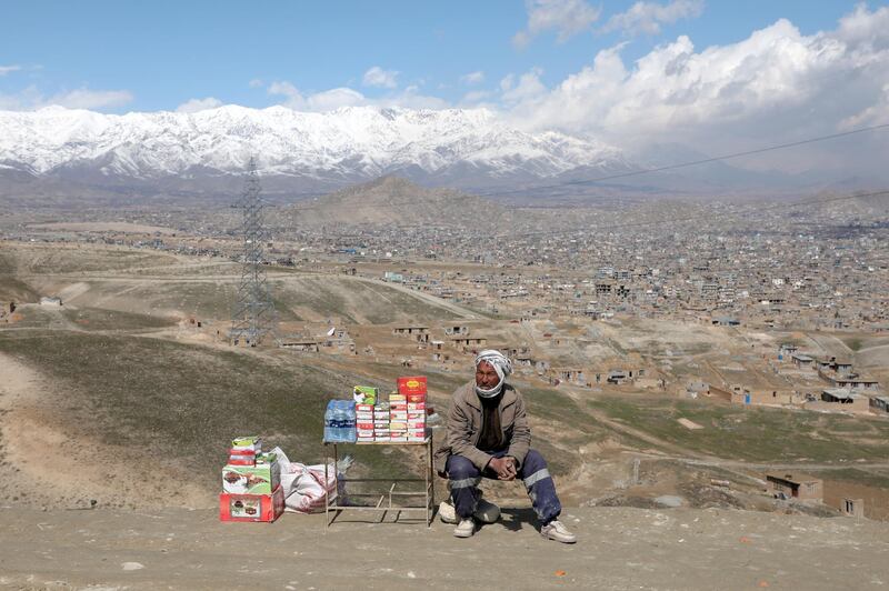 An Afghan man waits for customers, near a graveyard at a hilltop, as he sells dates in Kabul. Reuters