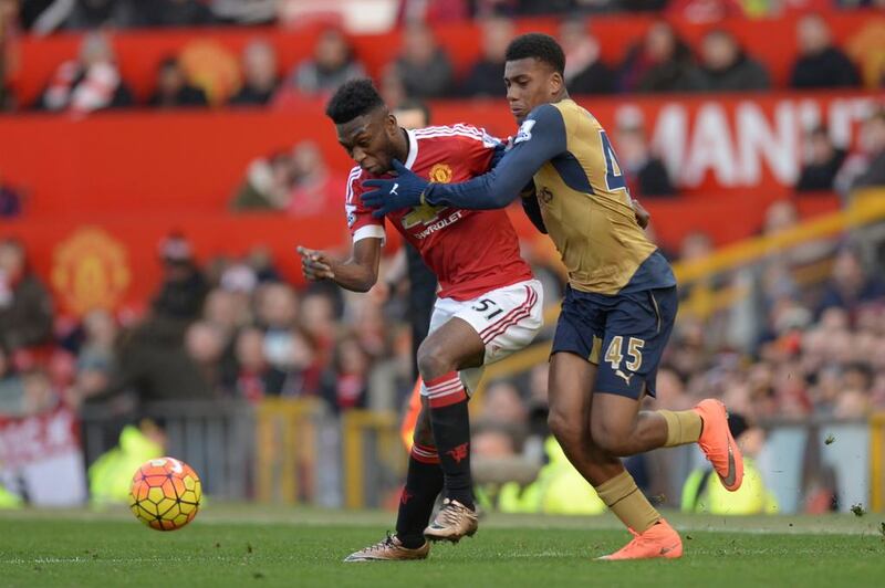 Manchester United’s Dutch defender Timothy Fosu-Mensah (L) and Arsenal’s Nigerian striker Alex Iwobi (R) battles for the ball during the English Premier League football match between Manchester United and Arsenal at Old Trafford in Manchester in north west England on February 28, 2016.