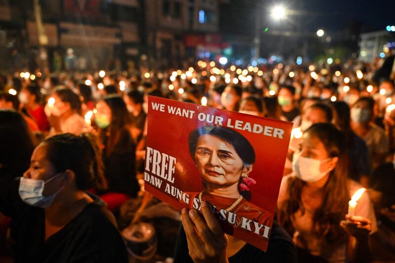 A protester holds a poster with an image of detained civilian leader Aung San Suu Kyi during a candlelight vigil to honour those who have died during demonstrations against the military coup in Yangon. AFP