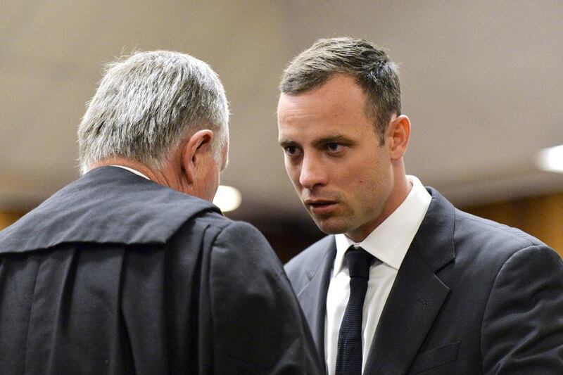 Oscar Pistorius, right, speaks with his lawyer Barry Roux in court on March 3, 2014, as his murder trail begins. Herman Verwey / AFP photo