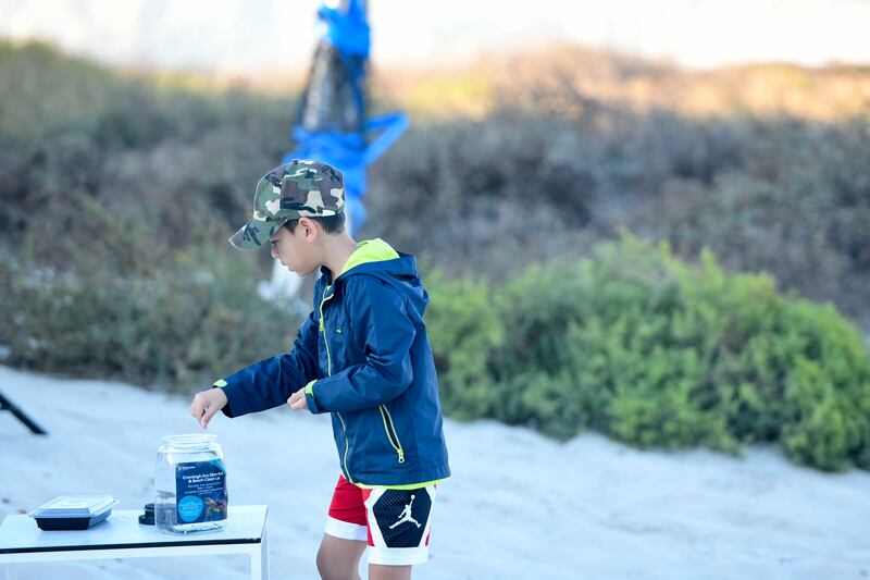 A child places nurdles in a jar