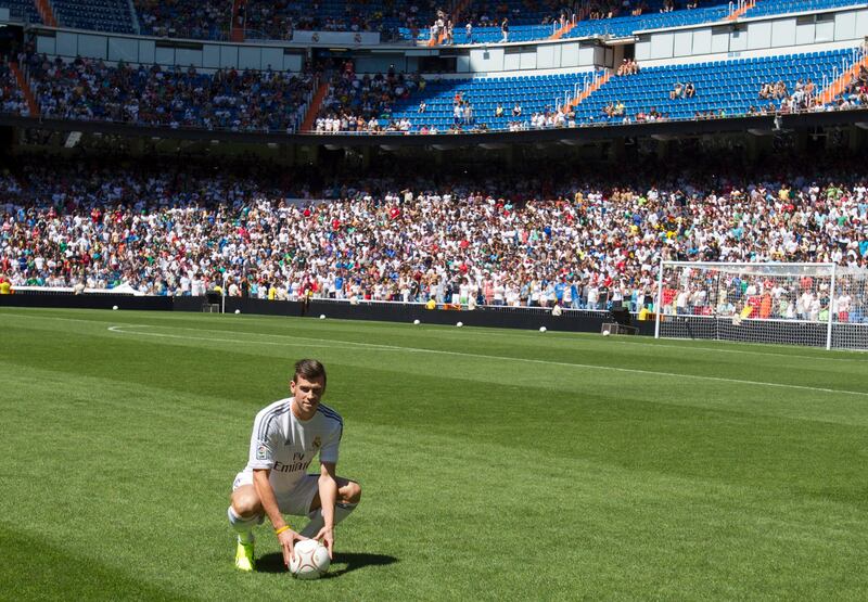 Welsh international soccer player Gareth Bale poses with a ball during his official presentation at the Santiago Bernabeu stadium in Madrid, Monday, Sept. 2, 2013 after signing for Real Madrid. The Spanish club announced Sunday that Bale has signed a six-year contract, and a person familiar with the deal said the fee was a world-record euro100 million ($132 million). (AP Photo/Paul White) *** Local Caption ***  Spain Soccer Real Madrid Bale.JPEG-0a2be.jpg