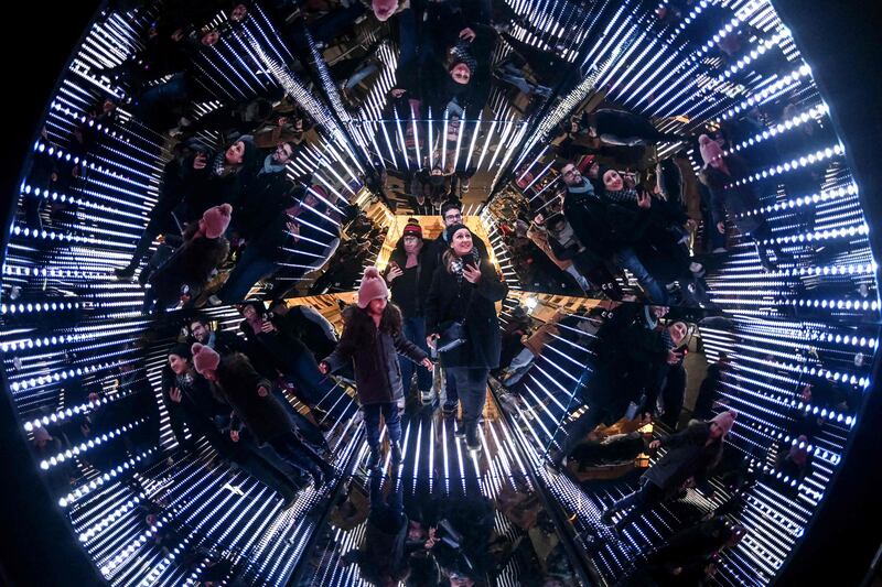 People stand in a giant kaleidoscope, an installation by French artist Guillaume Marmin, during the Festival of Lights in Lyon, France. AFP