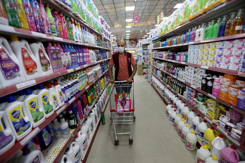 A Palestinian man wearing a mask pushes a cart with disinfectants in a supermarket in the southern Gaza Strip. Reuters