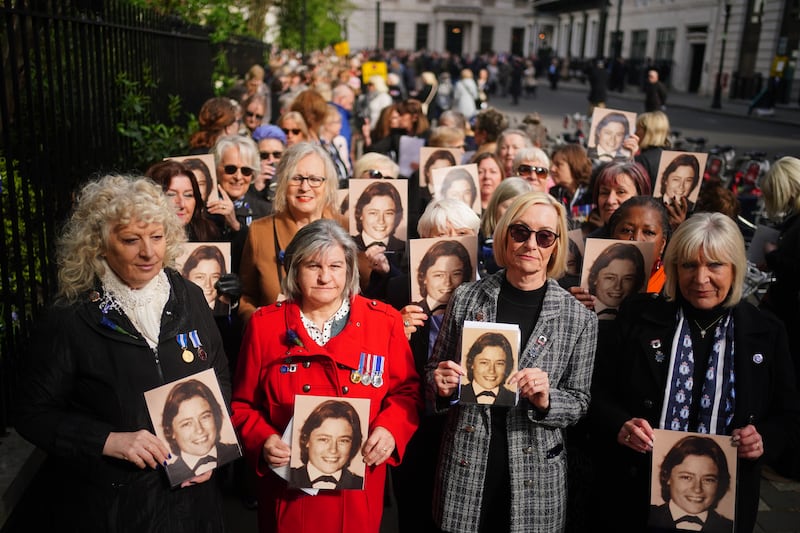 Former colleagues of Yvonne Fletcher hold photos of her in St James's Square, London, at a memorial service to mark the 40th anniversary of the police officer's death. PA