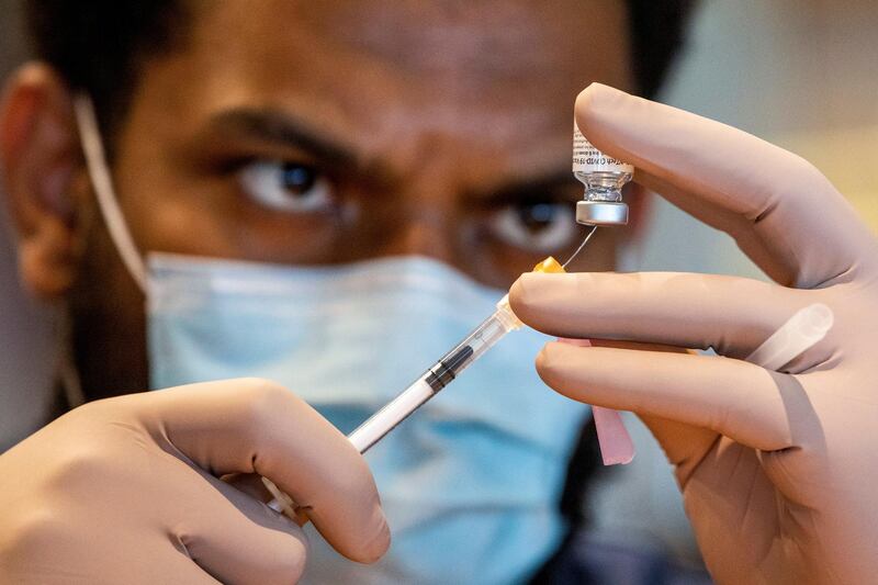 A healthcare worker prepares a dose of the Pfizer/BioNTech coronavirus disease (COVID-19) vaccine, which was authorized by Canada to be used for children aged 12 to 15, at Woodbine Racetrack pop-up vaccine clinic in Toronto, Ontario, Canada May 5, 2021. REUTERS/Carlos Osorio