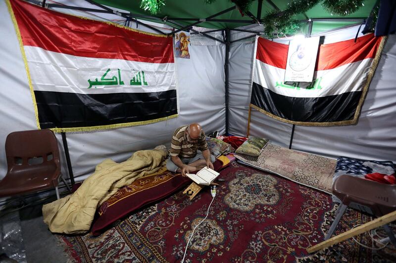 An Iraqi protester reads the Quran inside a tent at the mostly empty sit-in site at Al Tahrir square in central Baghdad, Iraq. EPA